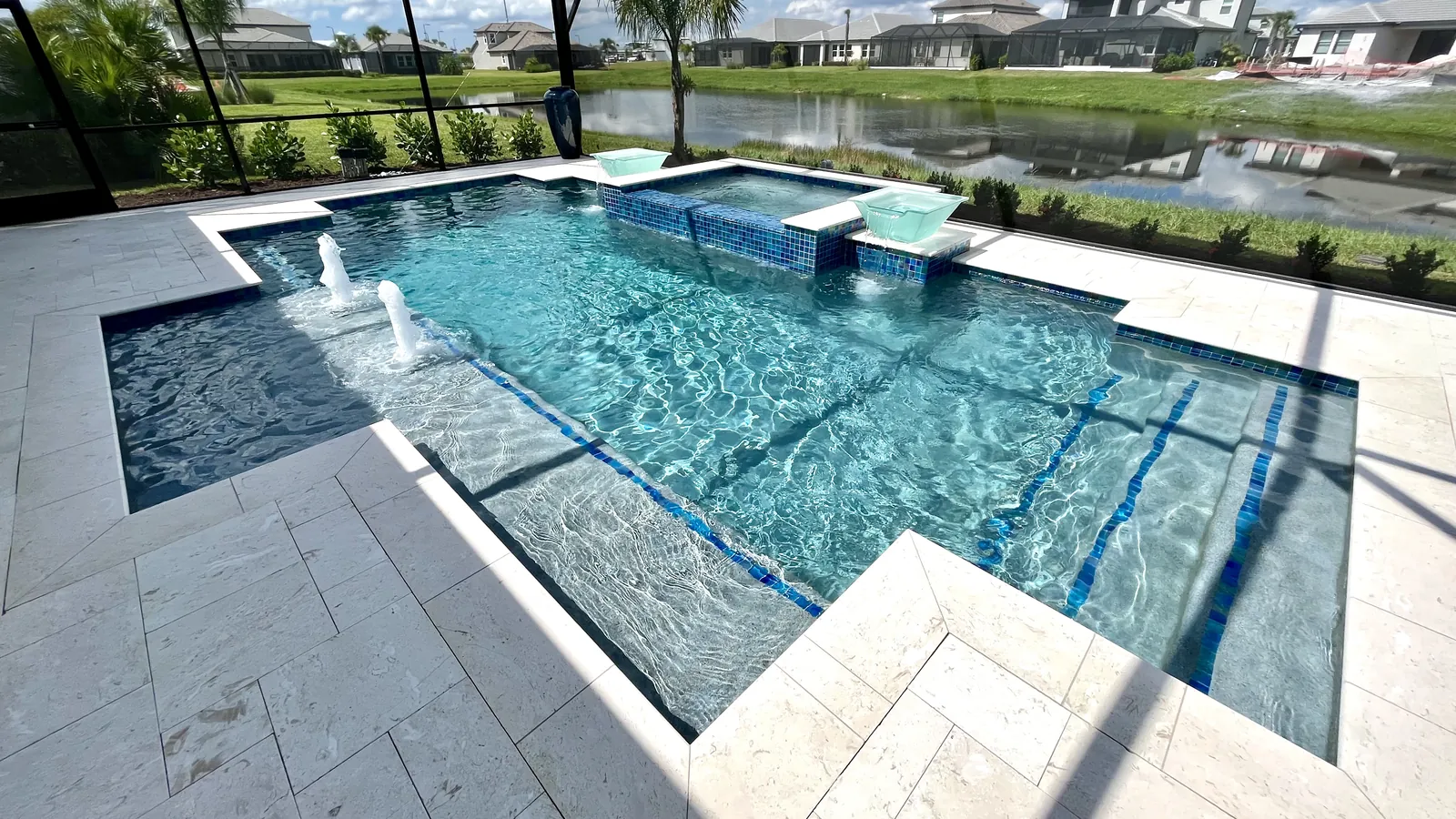 Geometric pool with a raised spa and sun shelf beside a lake