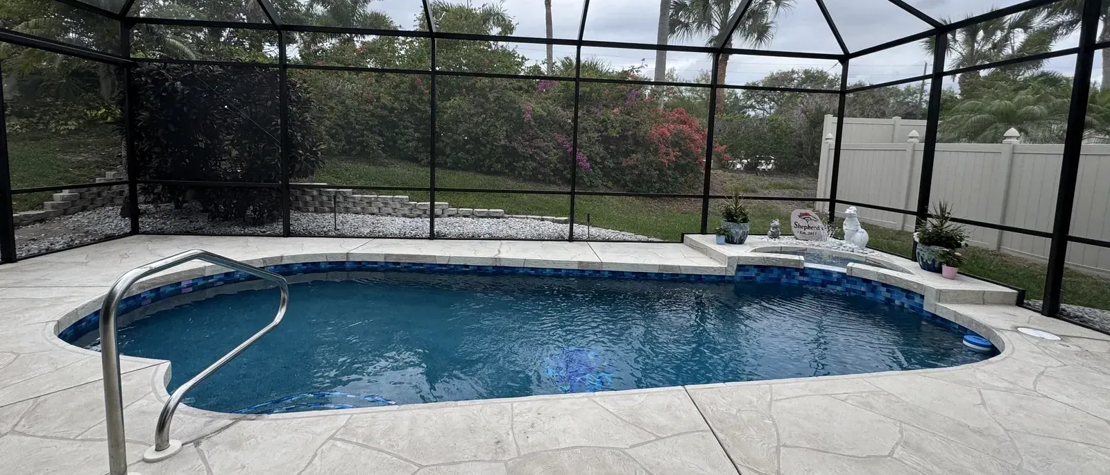 Remodeled pool in Parrish with new finish and glass tile under a screen enclosure